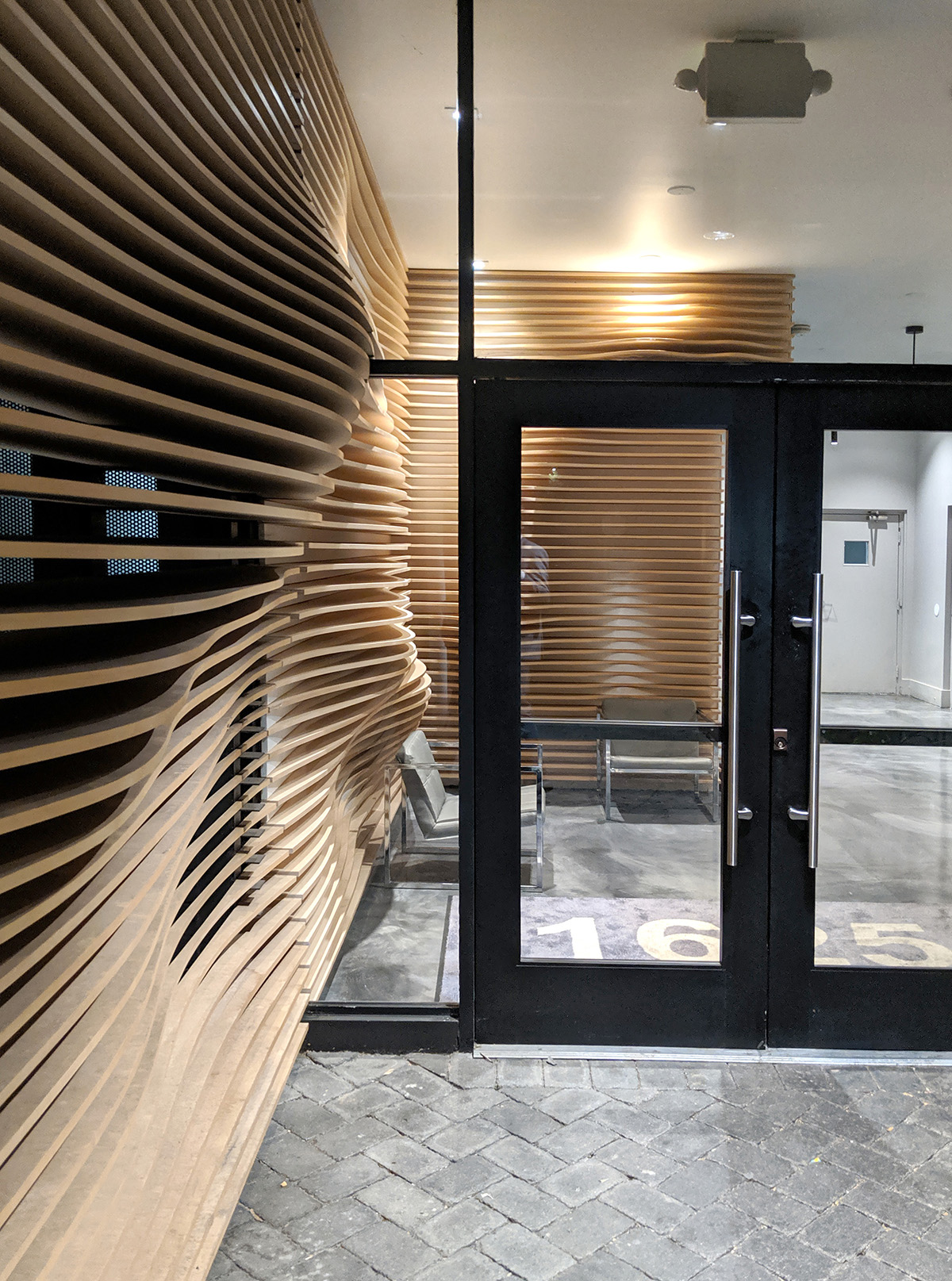 Wood boards that form a diffusing layer in an office lobby